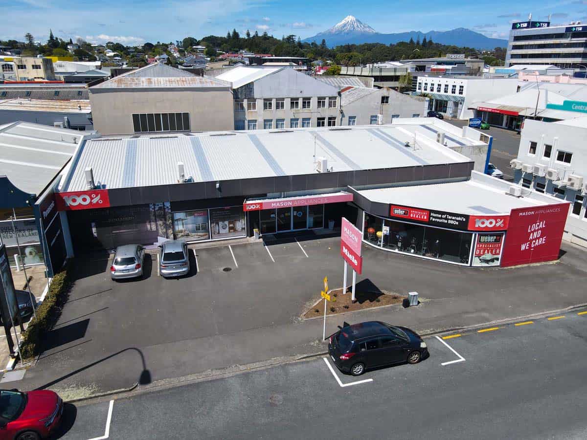 Aerial view of White Lion retail store at 86 Gill Street, featuring parking lot and surrounding buil.