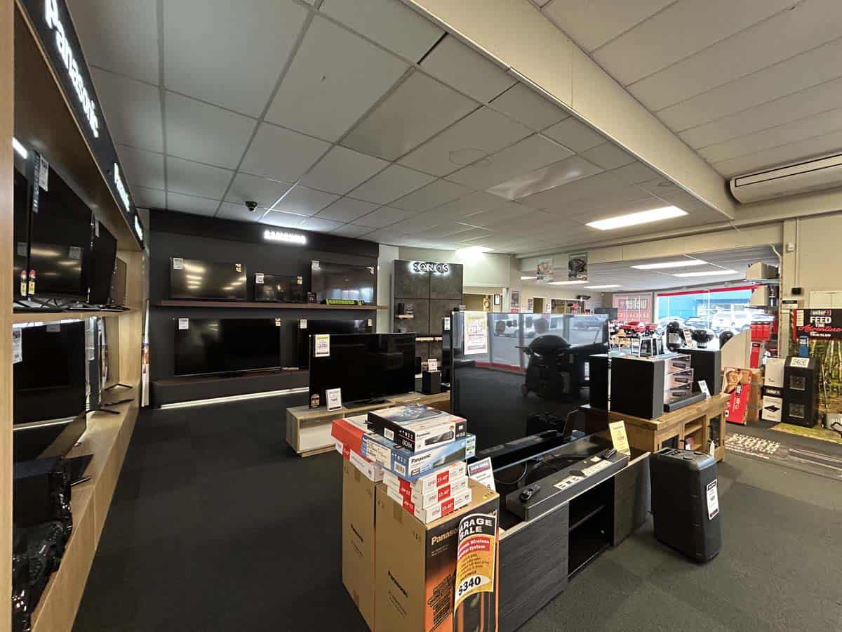 Modern electronics store interior with TVs, appliances, and tech accessories.
