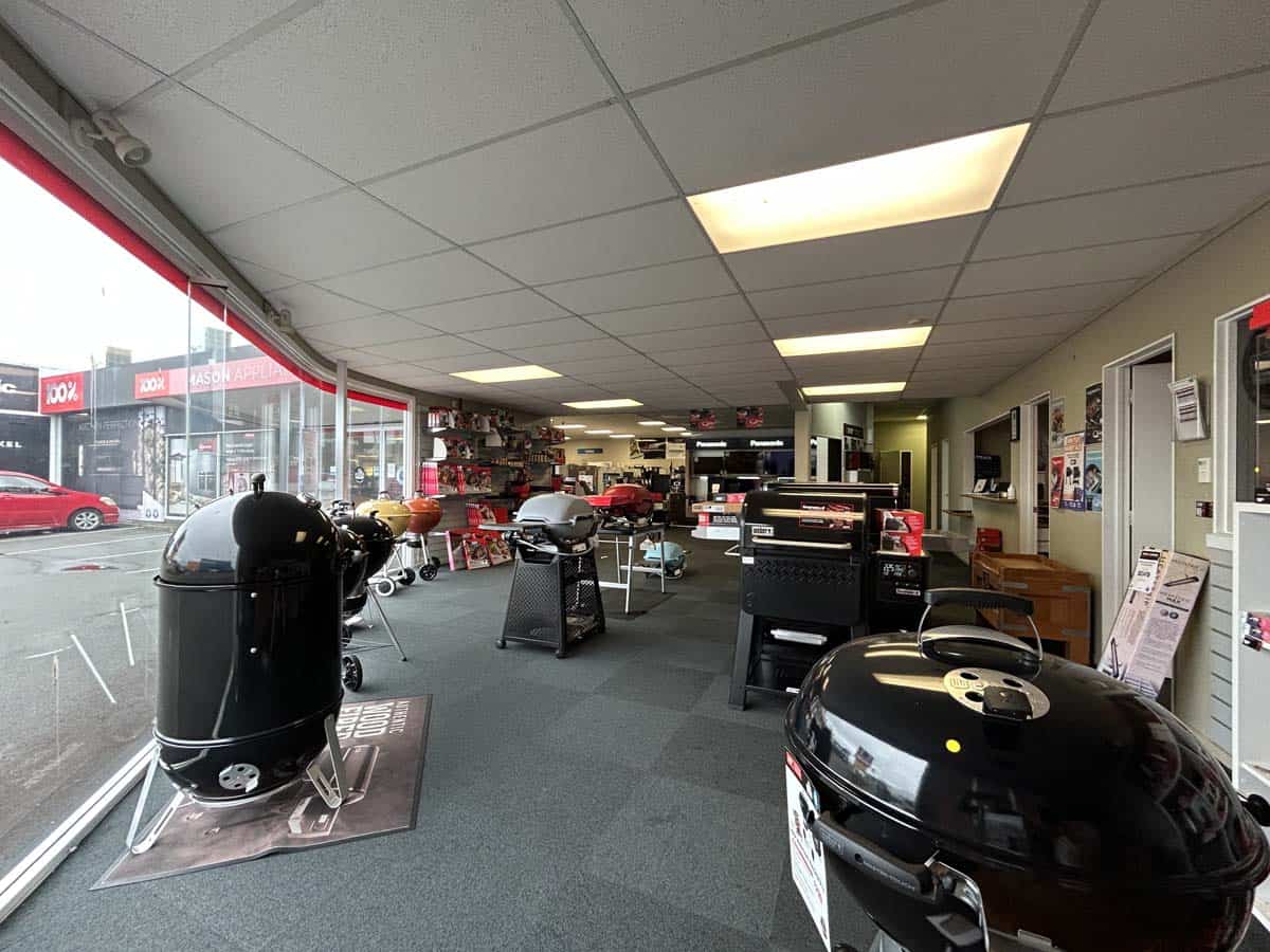 Interior view of White Lion car dealership at 86 Gill Street, featuring BBQ grills and automotive ac.