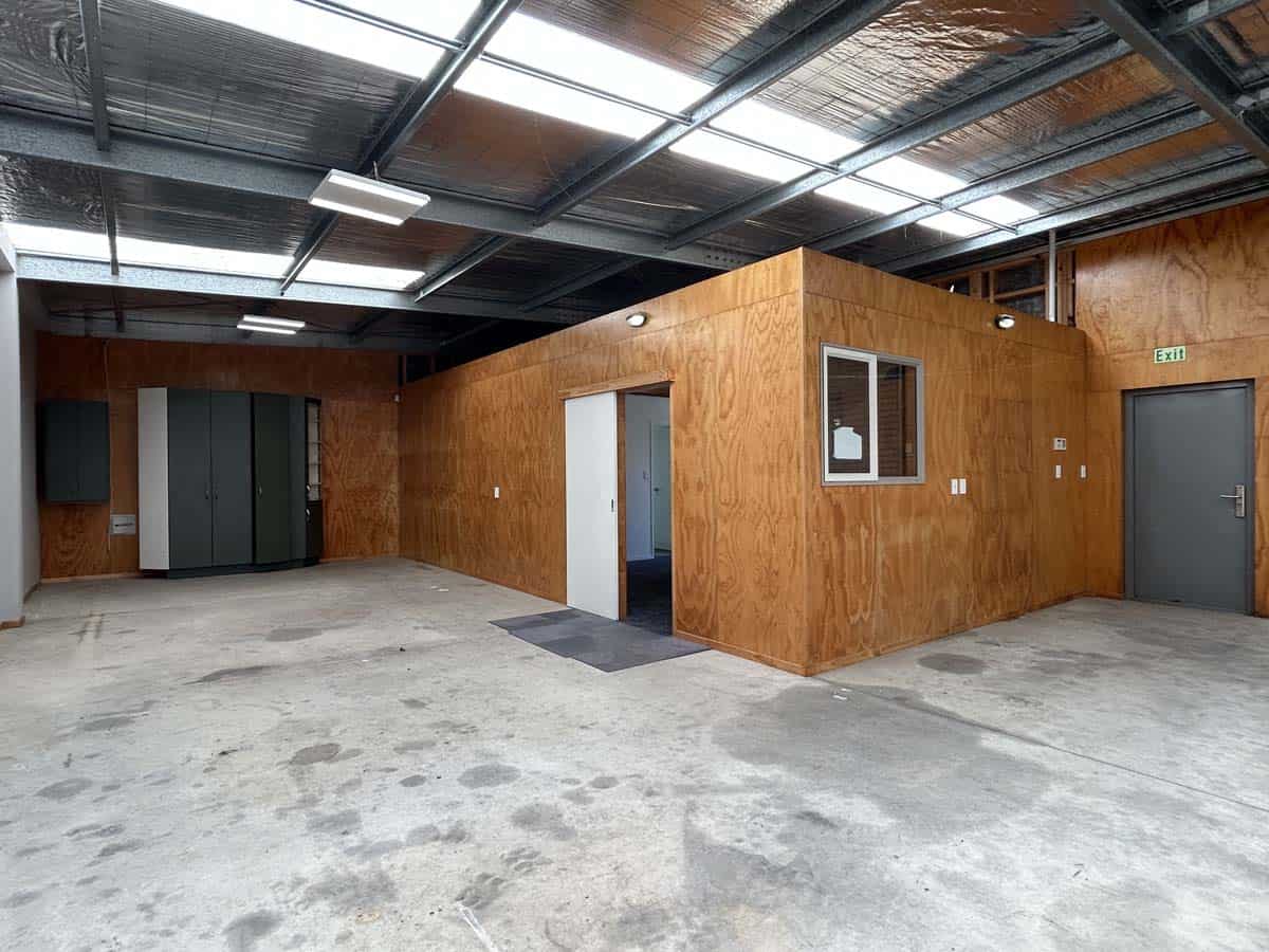 Modern industrial warehouse space with wooden walls and high ceilings.