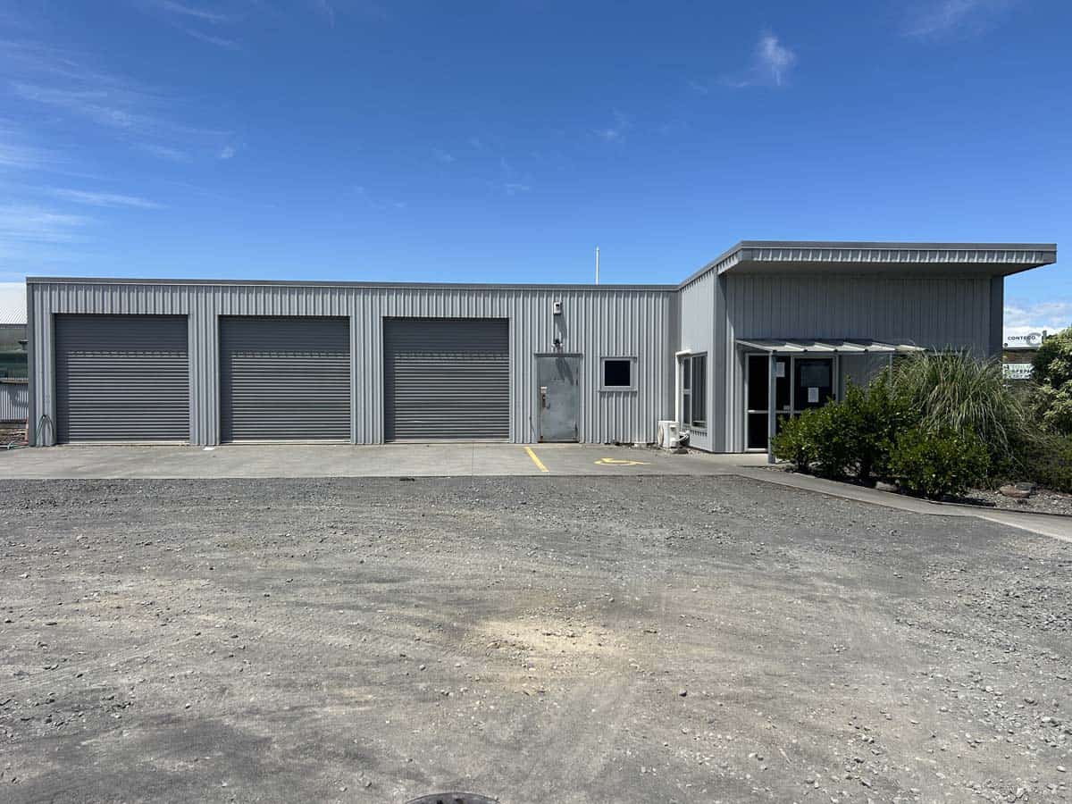 Modern industrial warehouse with multiple roller doors and office space.