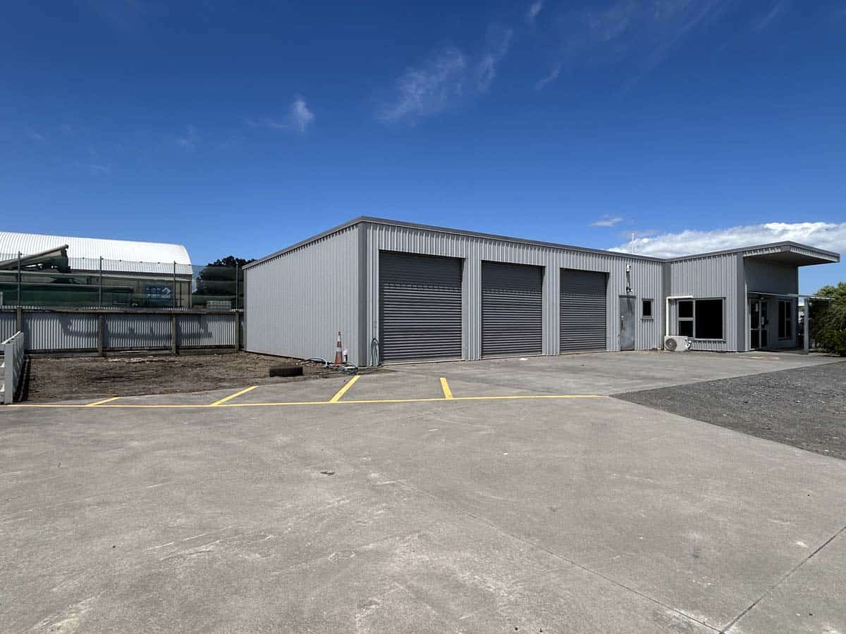 Modern industrial warehouse with multiple roller doors at 76 De Havilland Drive.