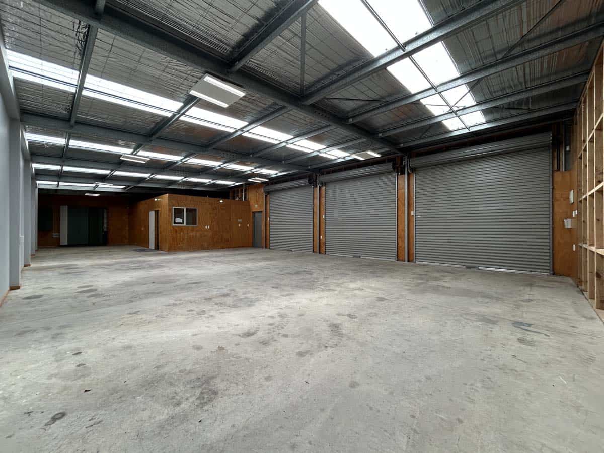 Industrial warehouse with high ceilings and roller doors at 76 De Havilland Drive.