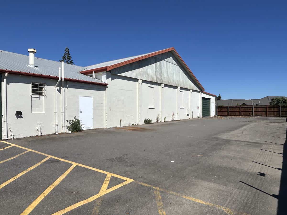 Commercial building with parking lot and clear sky.