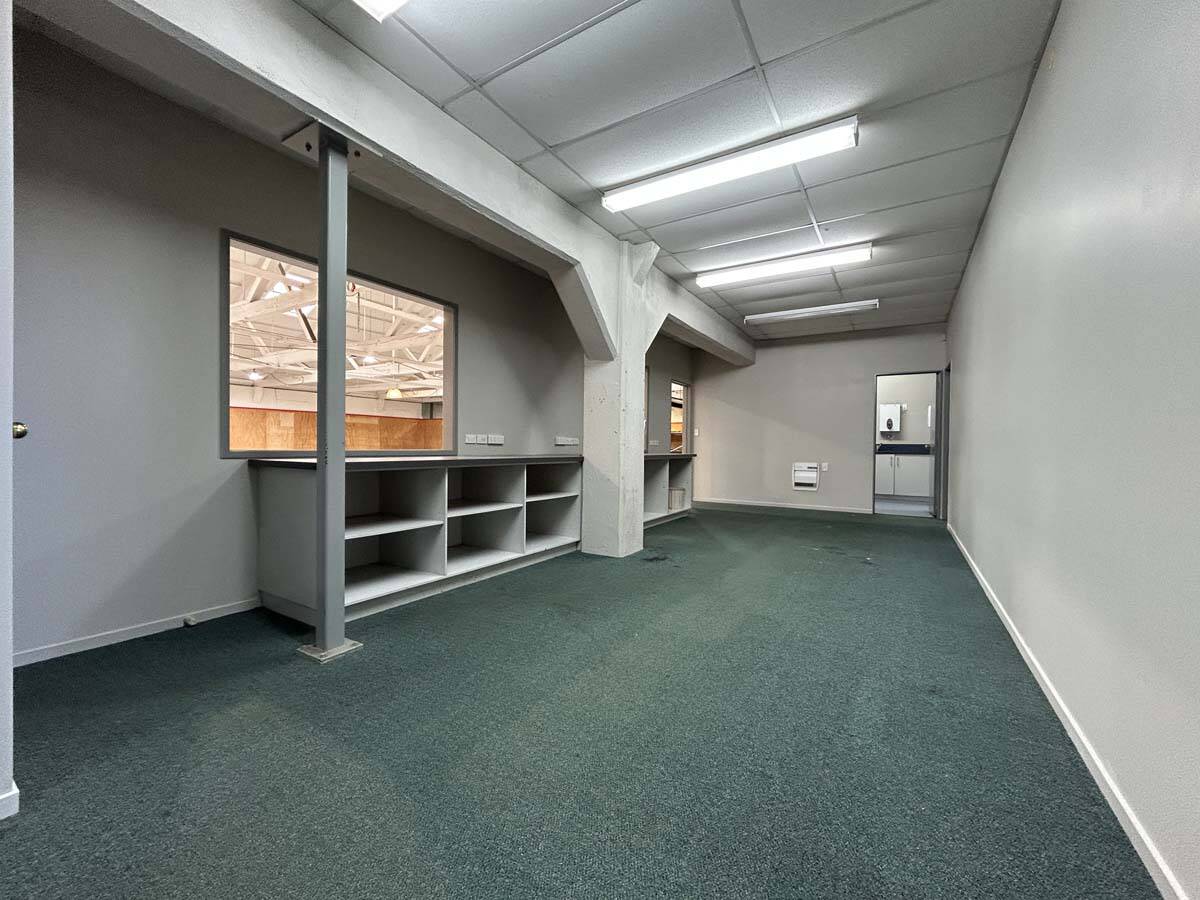 Modern office interior with storage shelves and large windows.