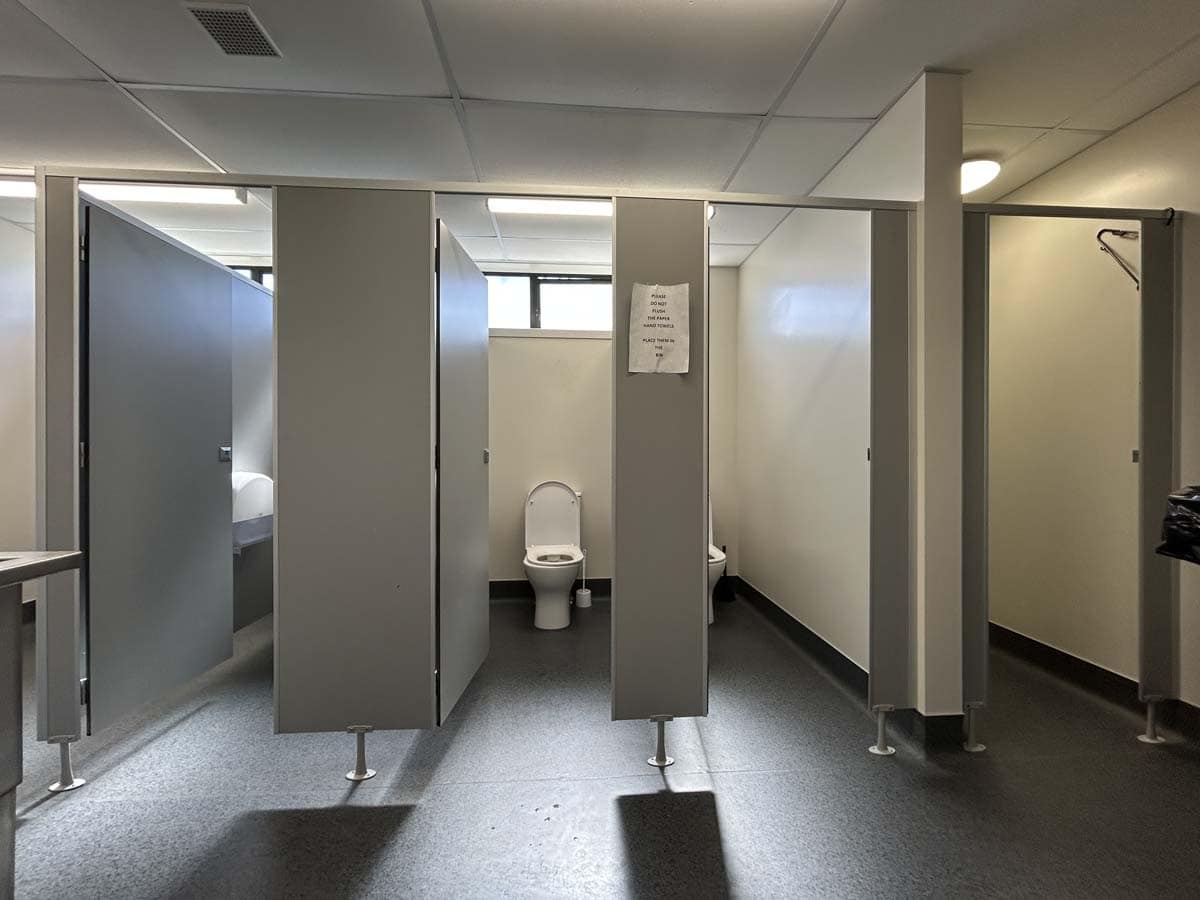Public restroom with multiple toilet stalls at 25 Cashew Street.