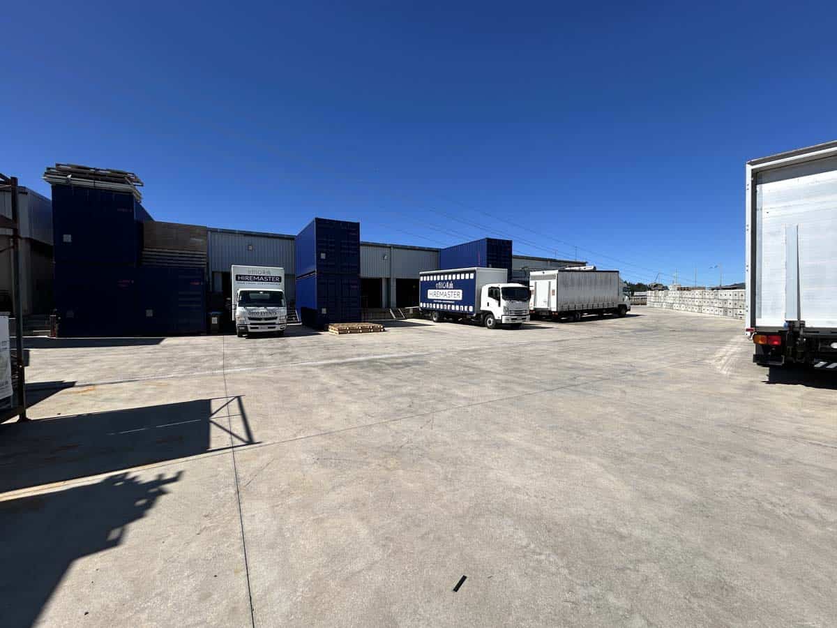 Industrial logistics yard with trucks and storage containers at 25 Cashew Street.