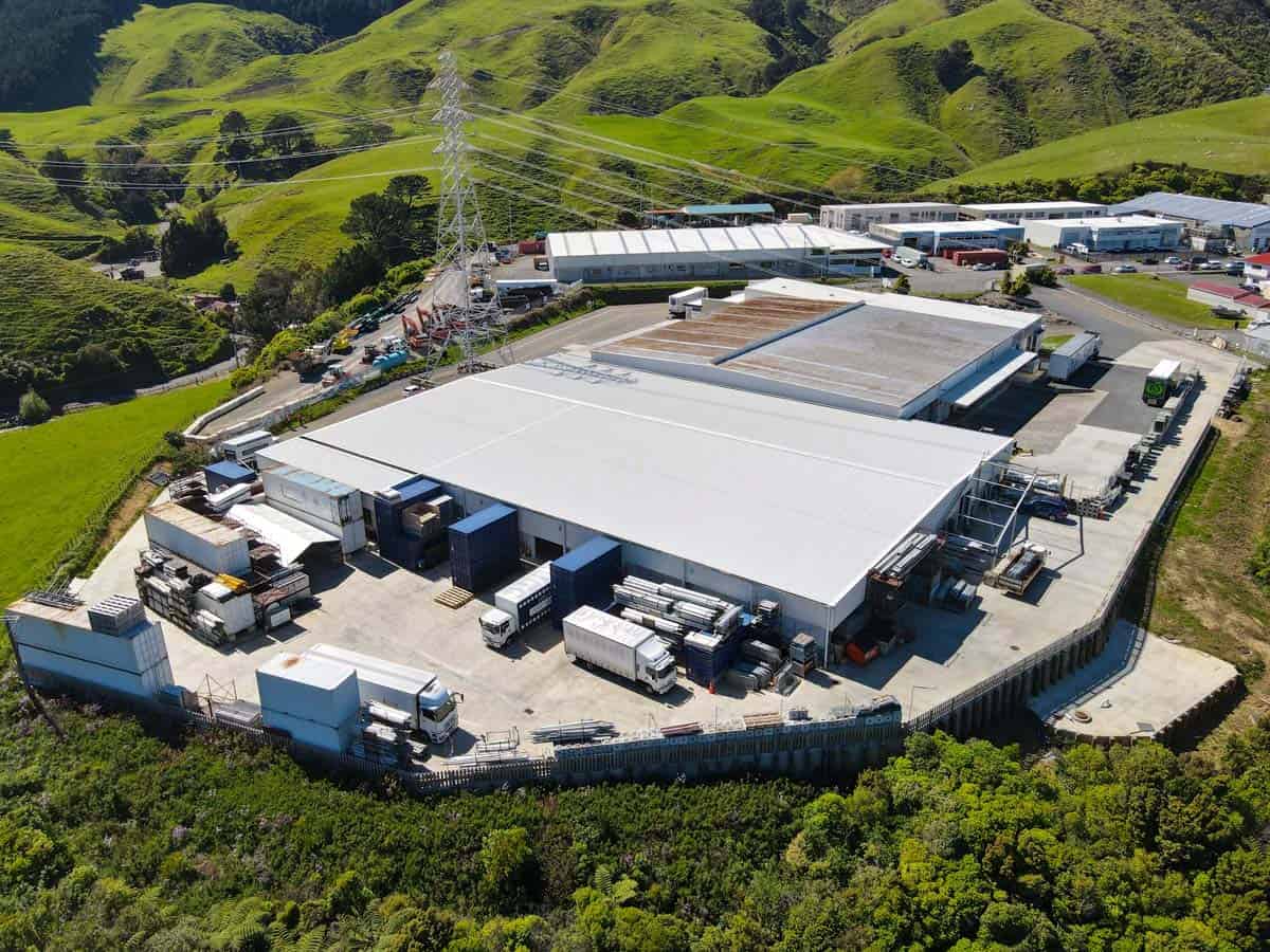 Aerial view of White Lion industrial warehouse surrounded by greenery and rolling hills.