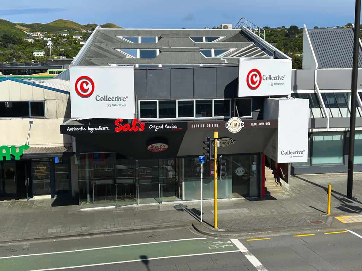 Modern commercial building at 20 Johnsonville Road with retail stores and signage.