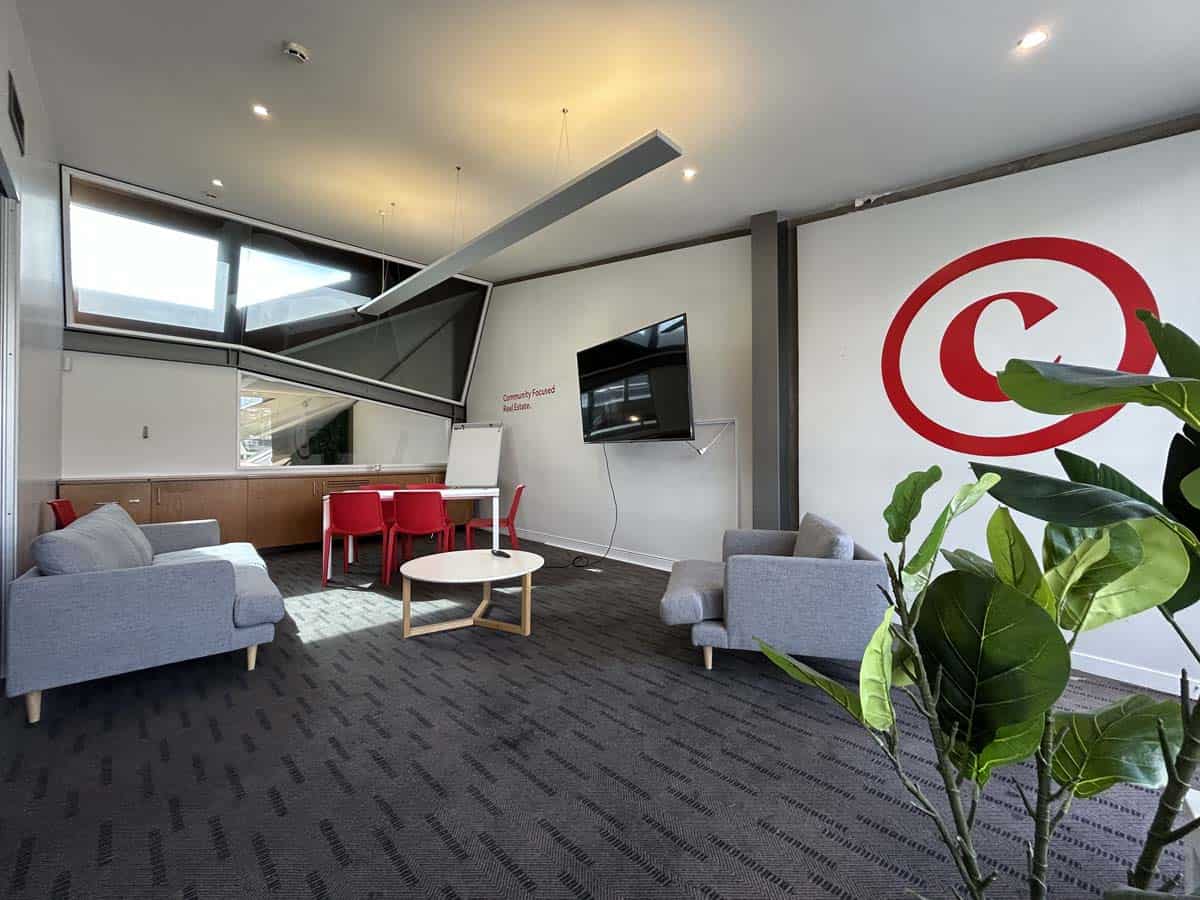 Modern office lounge with seating, TV, and greenery at White Lion, Johnsonville.