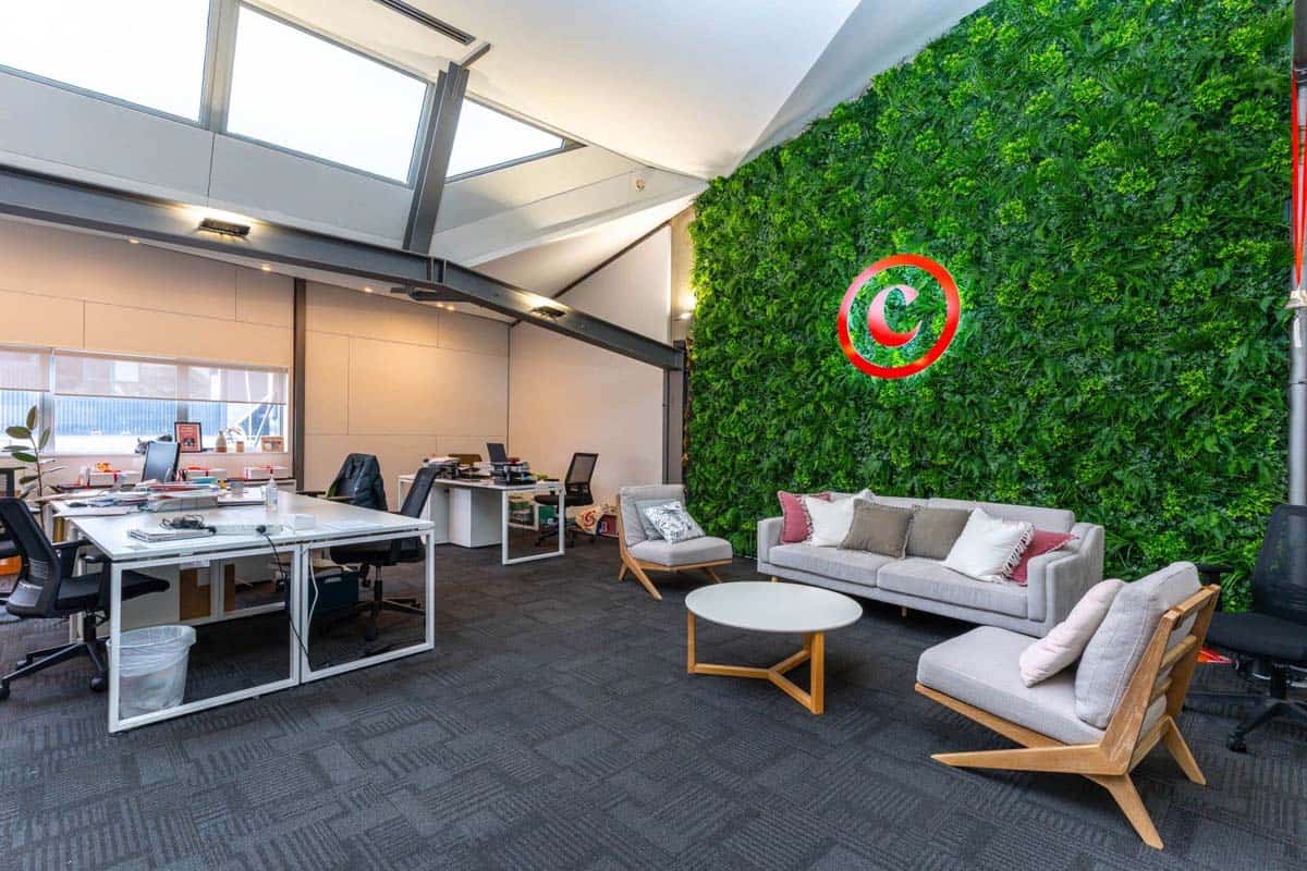 Modern office space with green wall and comfortable seating area.