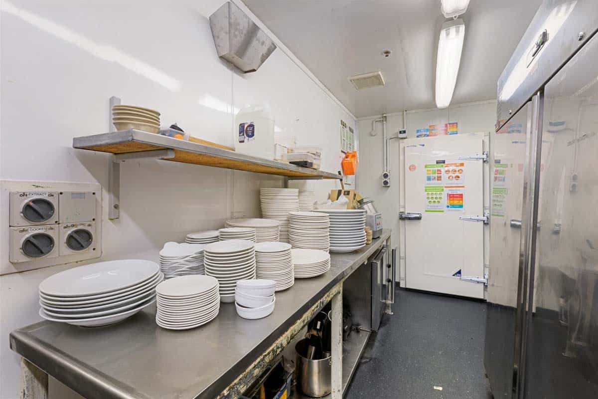 Commercial kitchen with stacked plates and cooking equipment at 31 Gover Street.