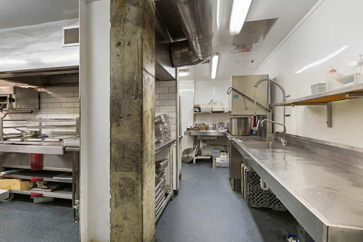 Modern commercial kitchen at White Lion, 31 Gover Street, featuring stainless steel surfaces and coo.