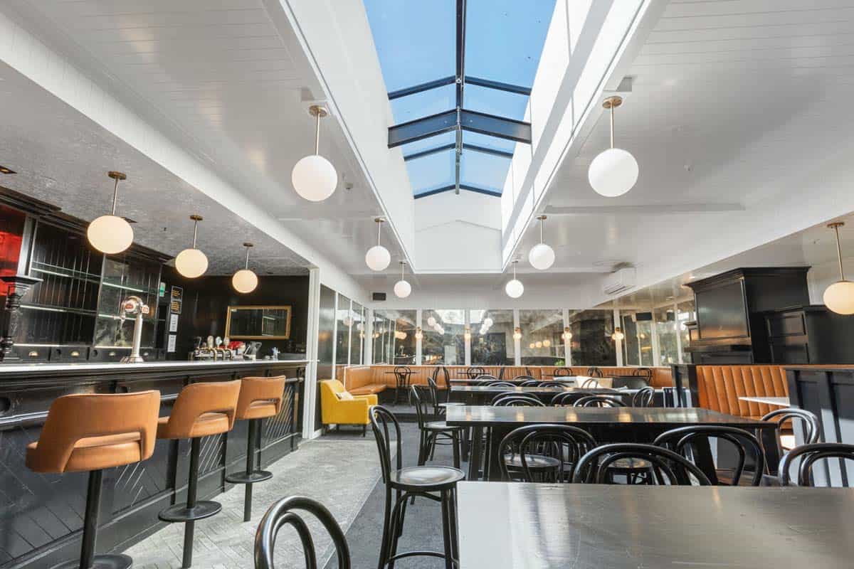 Modern interior of White Lion bar with natural light, stylish seating, and contemporary decor.