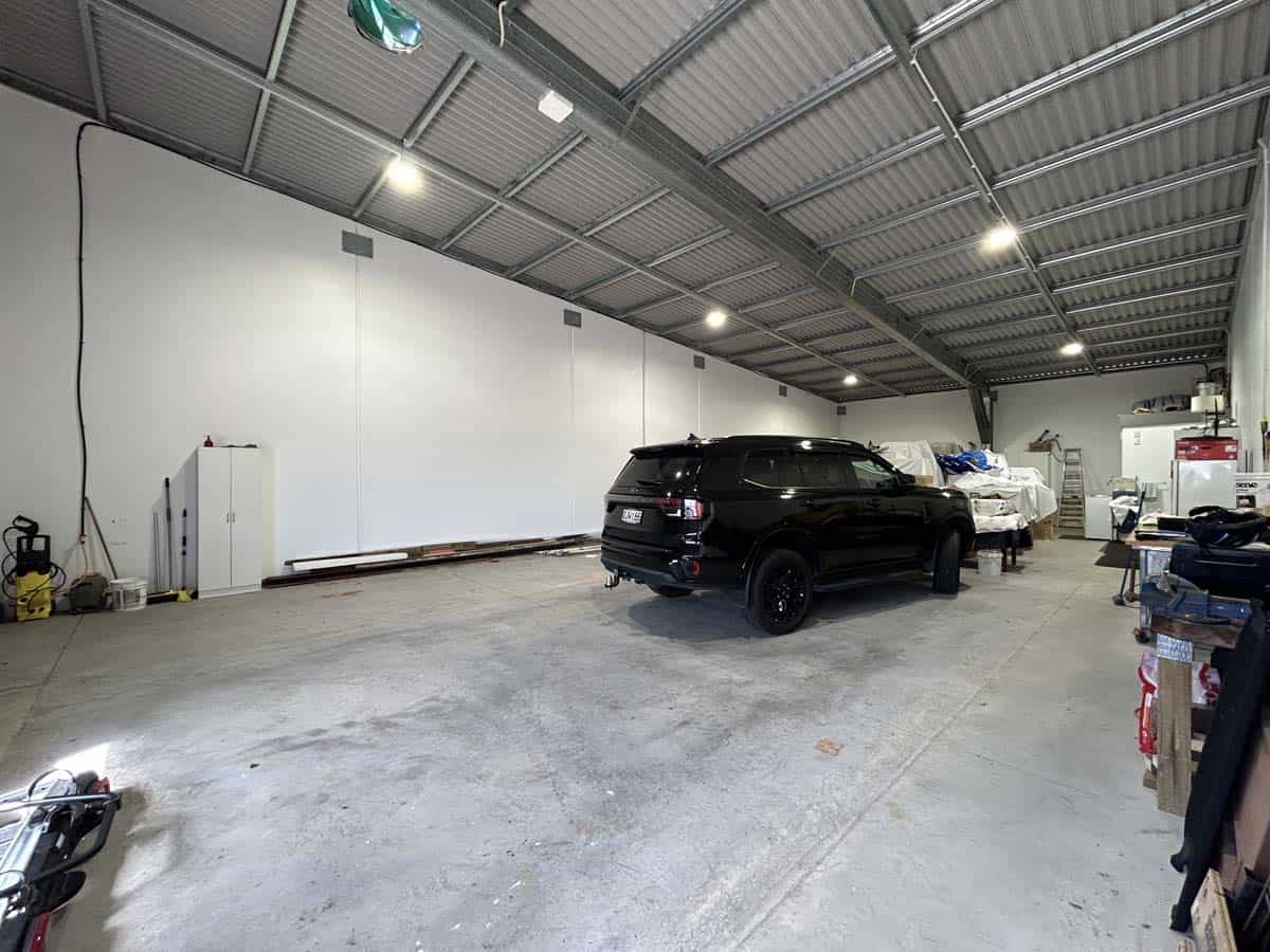 Indoor warehouse space with vehicles and storage area.