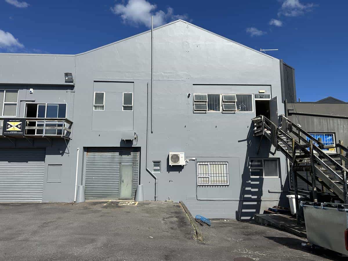 Modern industrial building with grey facade and external staircase at 100 Gill Street, White Lion.