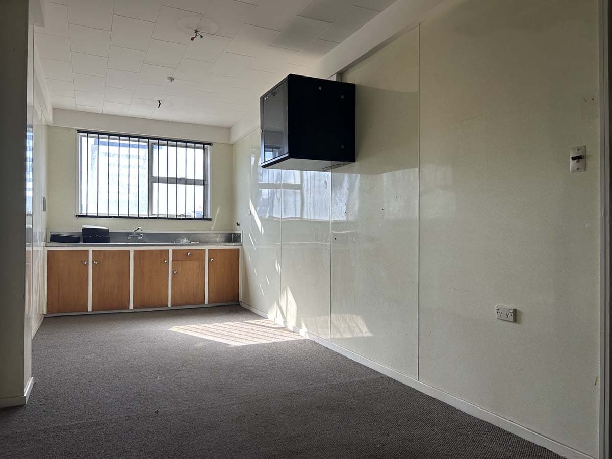Modern office interior with large window and wall-mounted TV.