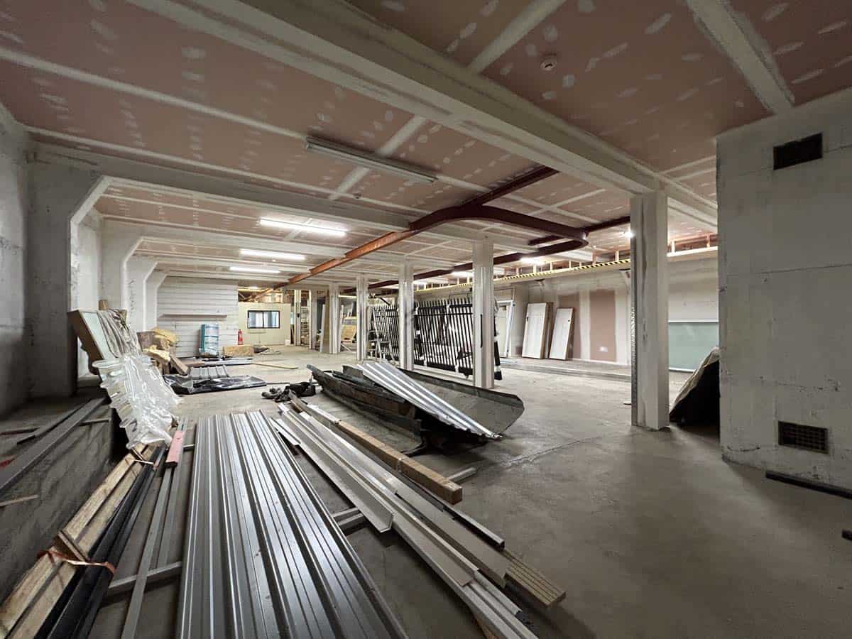 Construction site with building materials inside a commercial space.