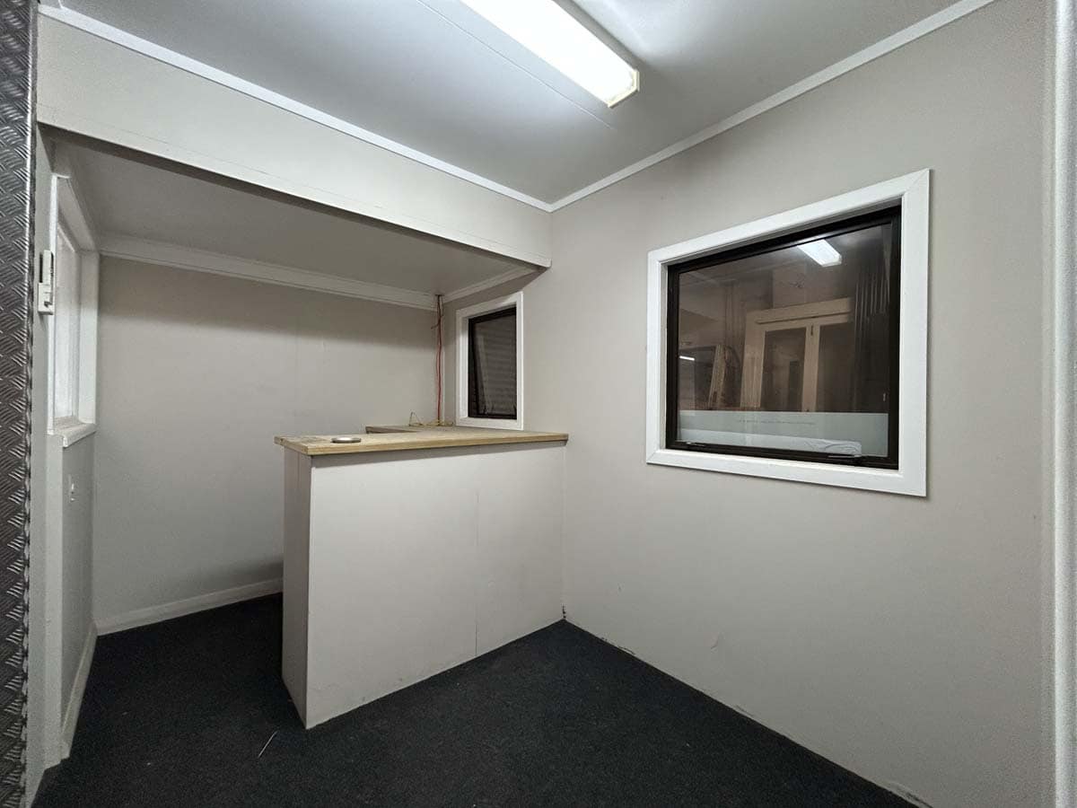 Interior view of a modern office space with white walls and large window.