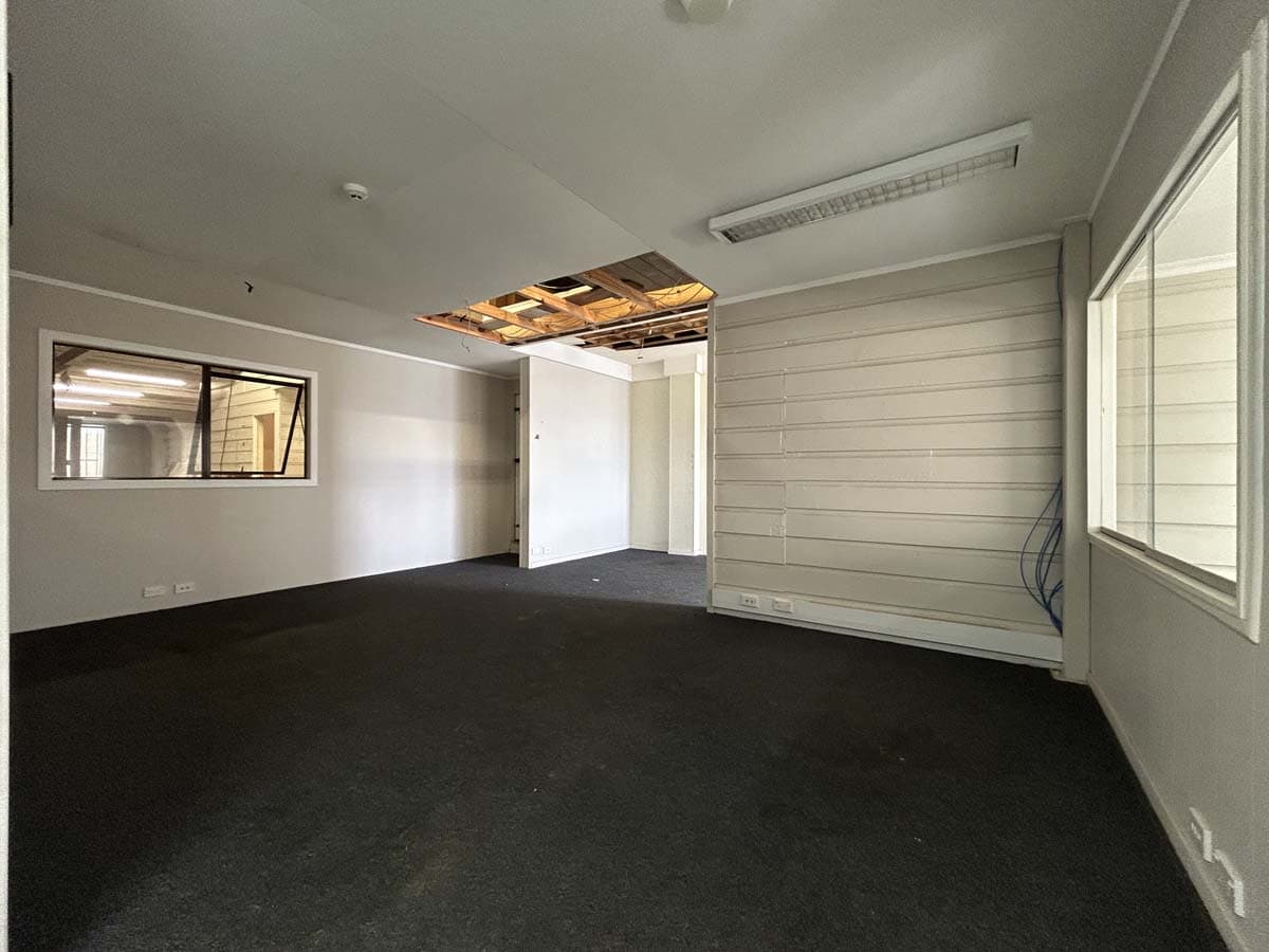 Modern office interior with white walls, large windows, and black carpet at 100 Gill Street.