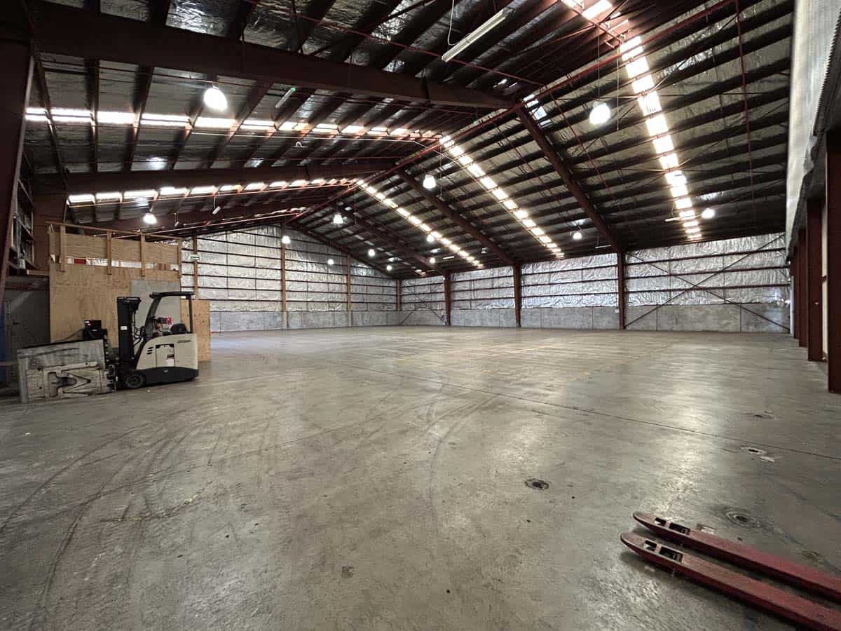 Large industrial warehouse space with high ceilings and concrete floor.