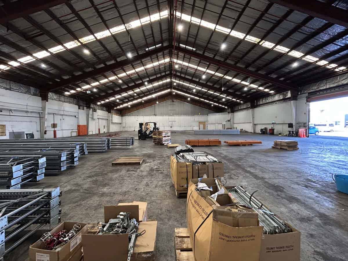 Spacious warehouse with metal racks, boxes, and forklift at White Lion, 38 East Street.