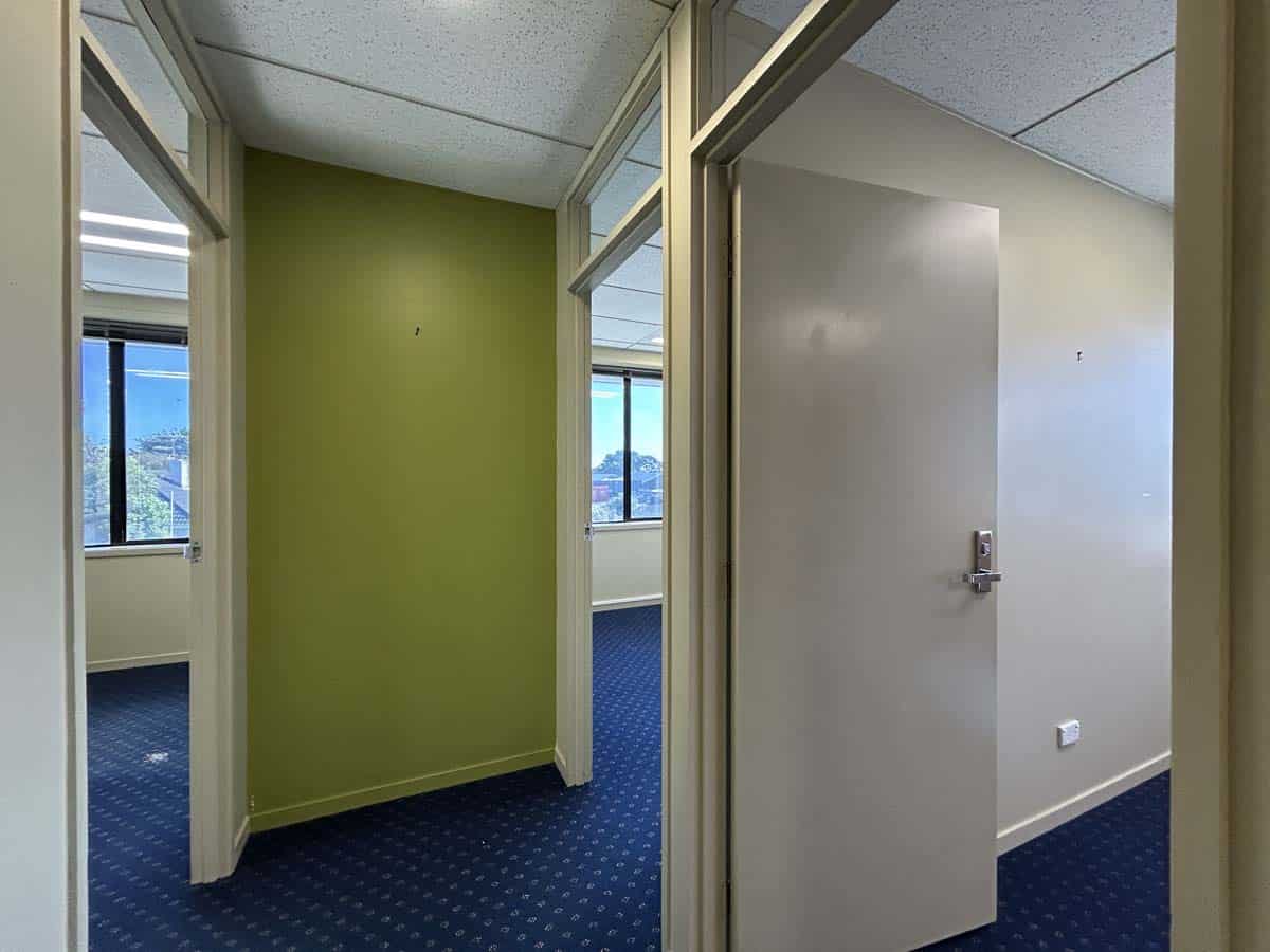 Bright office space with partitioned rooms and large windows at 5 Clinton Street.