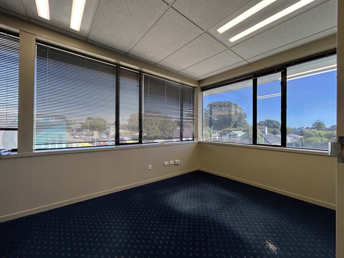 Bright office space with panoramic windows and blue sky view.