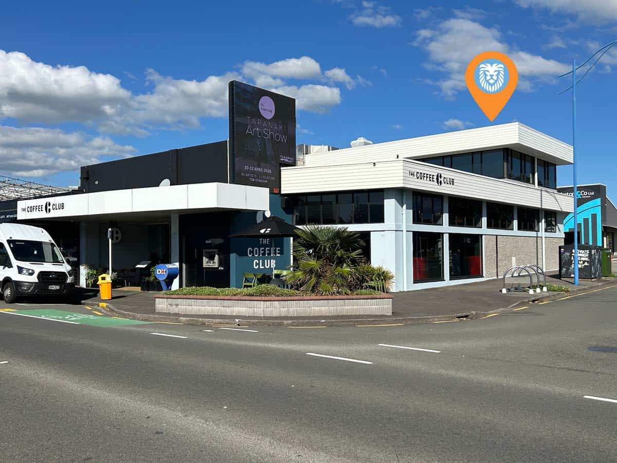 Modern White Lion building on Clinton Street with coffee shop and signage.