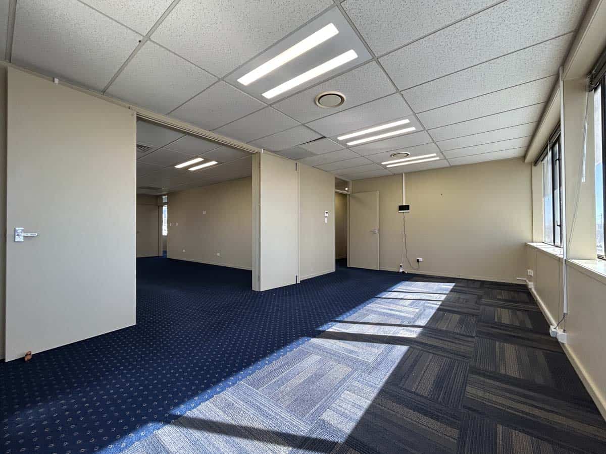 Bright office interior with large windows and modern lighting.