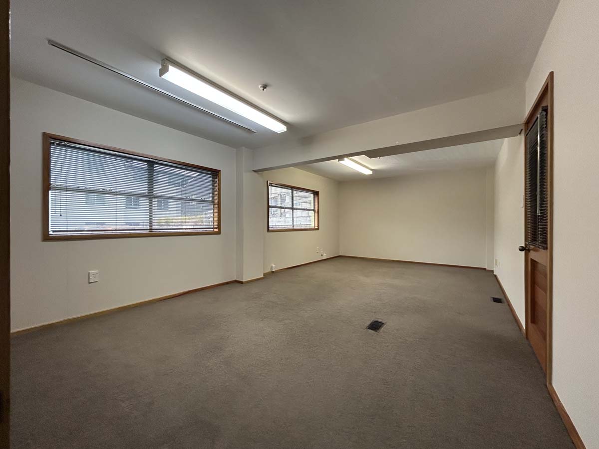 Empty office room with large windows and carpet flooring at Powderham Business Centre.
