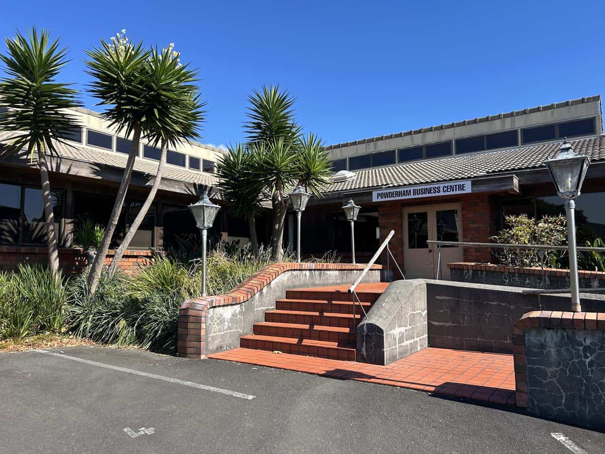 Exterior view of Powderham Business Centre entrance with lush plants and steps.