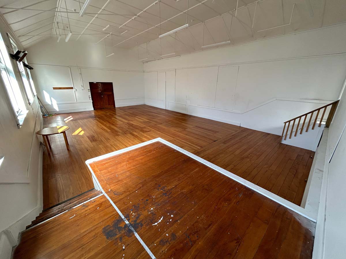 Spacious empty room with wooden floors and natural light at White Lion, 74 Powderham Street.