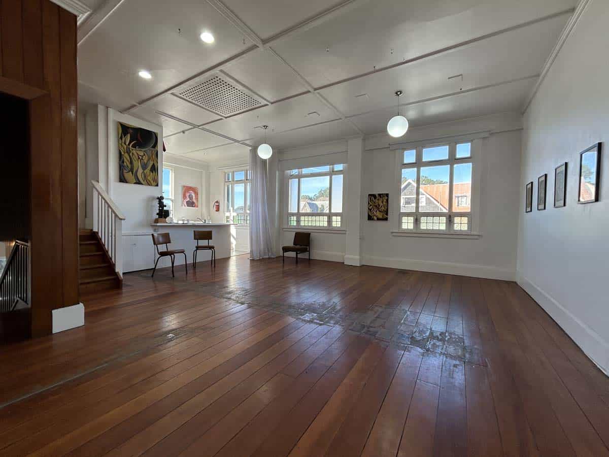 Bright, spacious room with large windows and wooden floors.