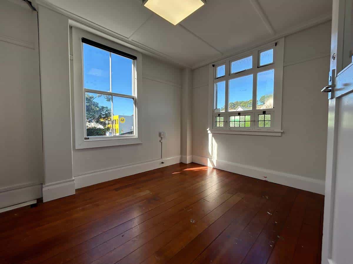 Bright office room with large windows and wooden floors at 74 Powderham Street.