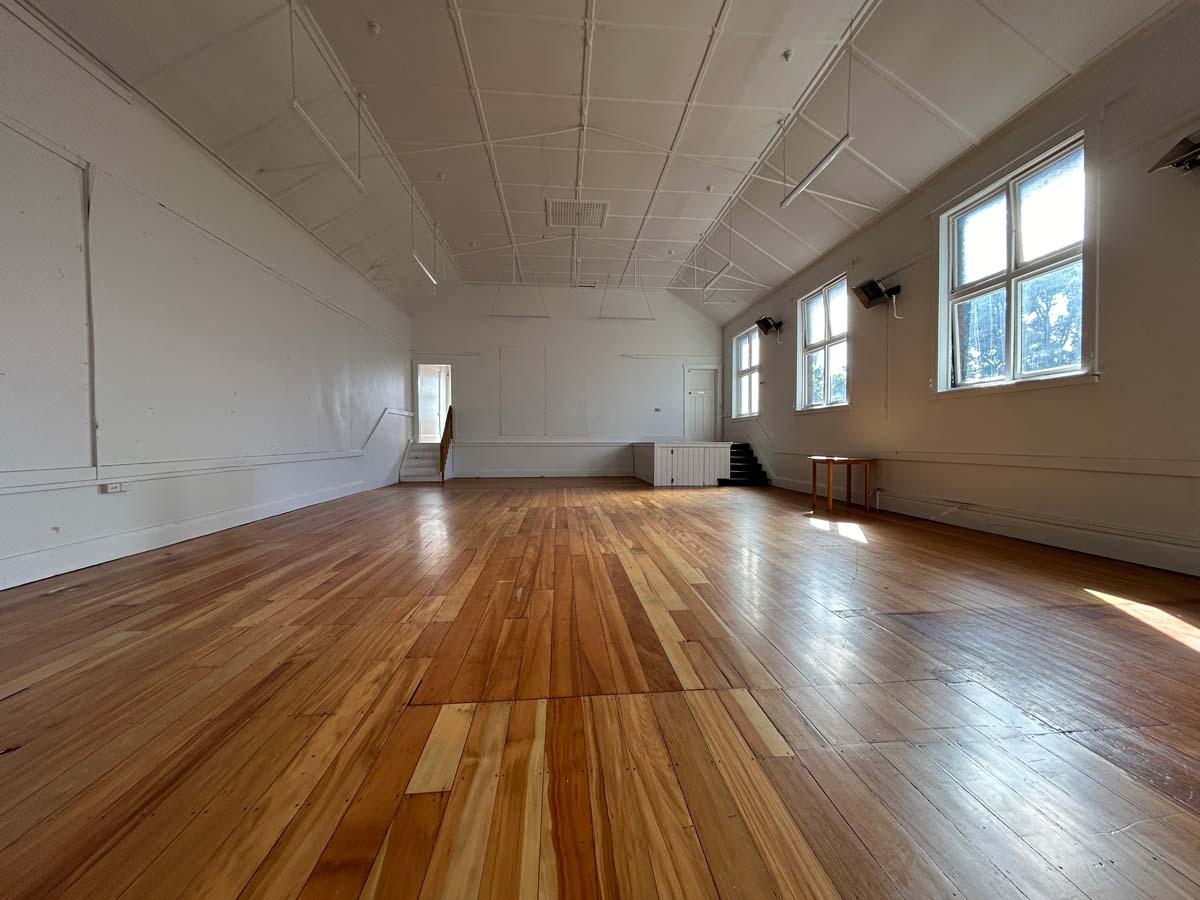 Spacious interior of White Lion venue with wooden floors and large windows.