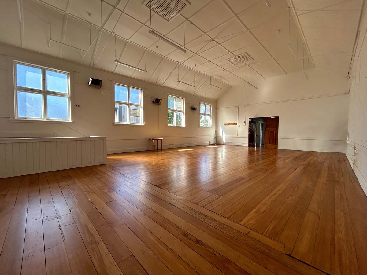Spacious room with wooden floors and large windows at White Lion, 74 Powderham Street.