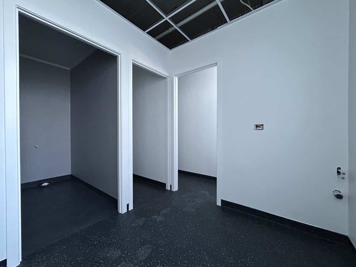 Modern office interior with multiple rooms and white walls in a commercial building.