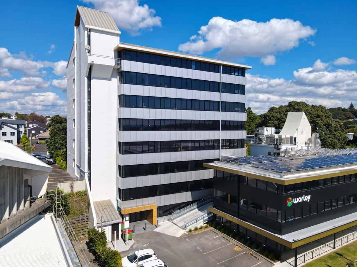 Modern White Lion office building in Auckland with glass facade and surrounding greenery.