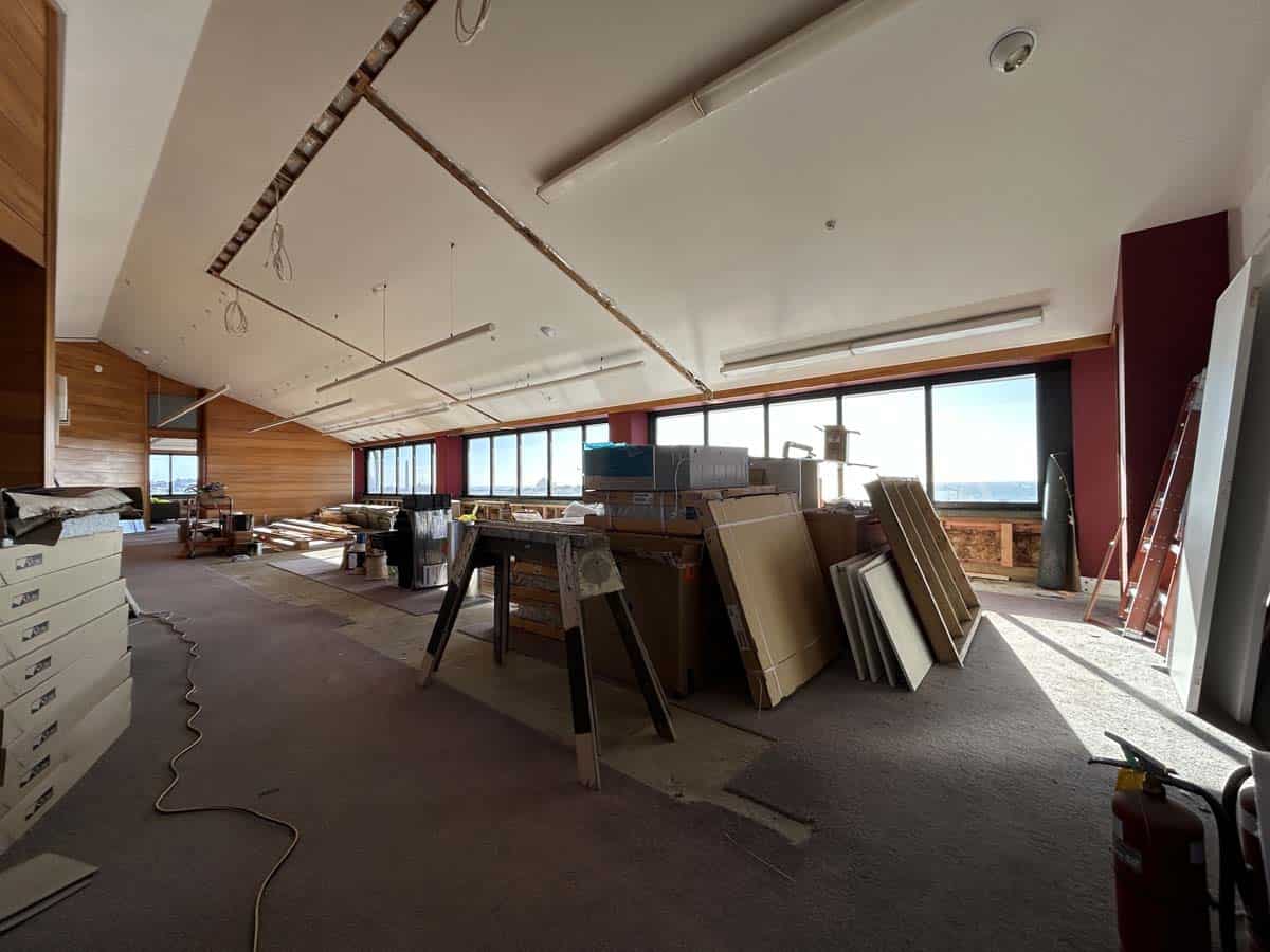 Interior view of a modern office space under construction with building materials and tools.