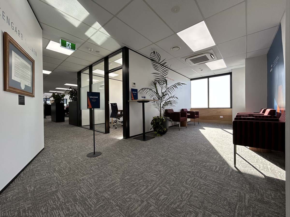 Modern corporate office reception with seating and natural light.