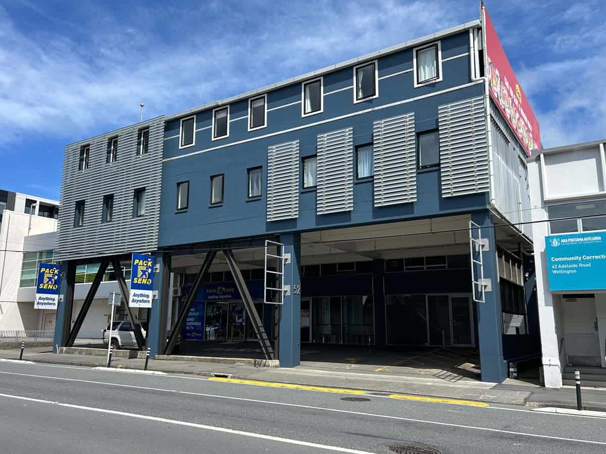 Modern blue commercial building with multiple windows and signage in Auckland.