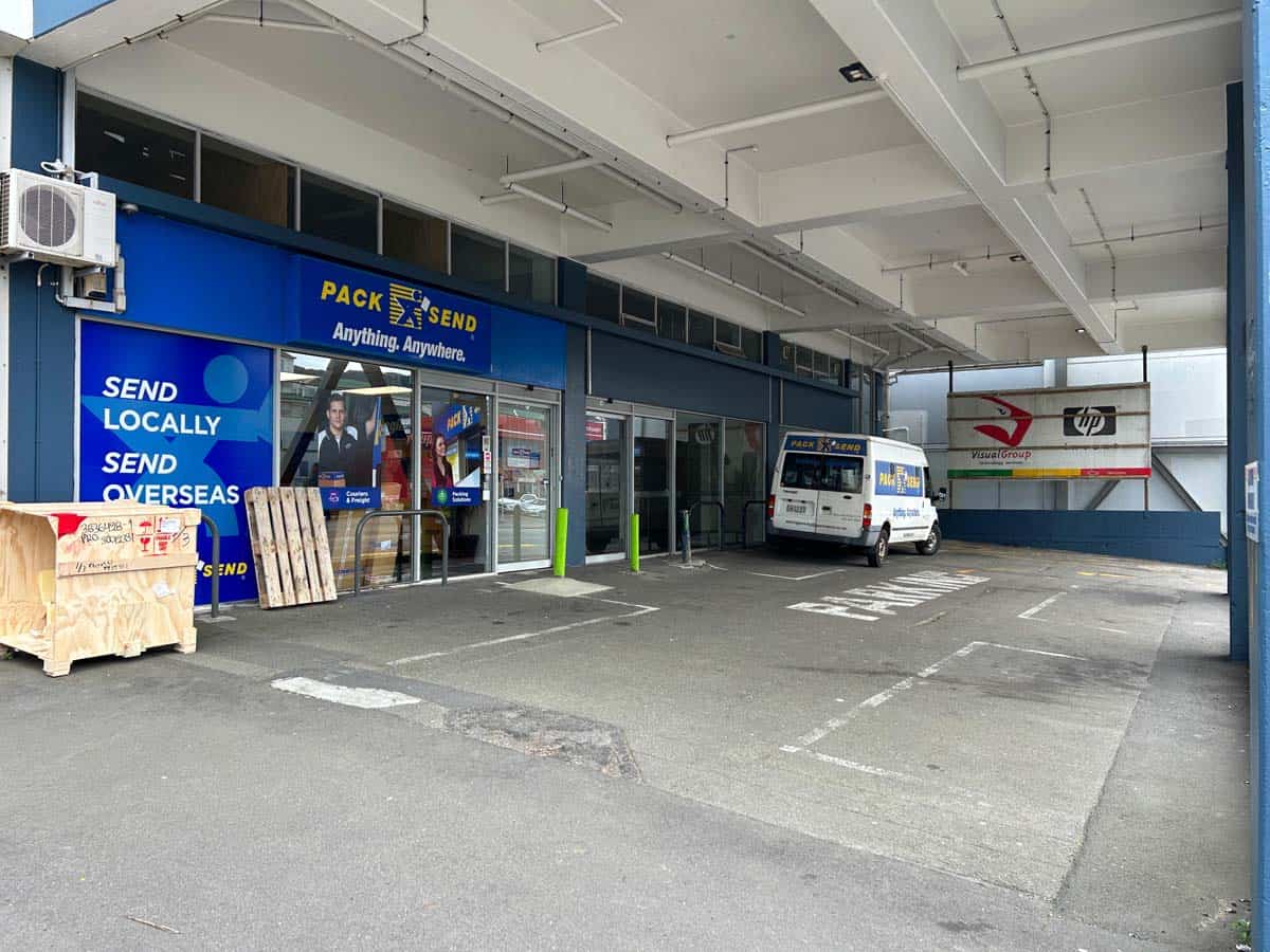 Courier drop-off area at Auckland airport with Pack & Send and DHL signage.