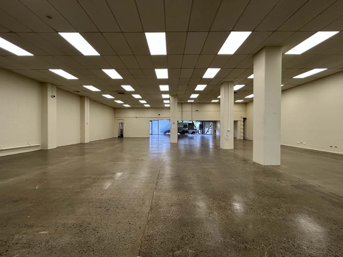 Empty commercial retail space in New Zealand with high ceilings and bright lighting.