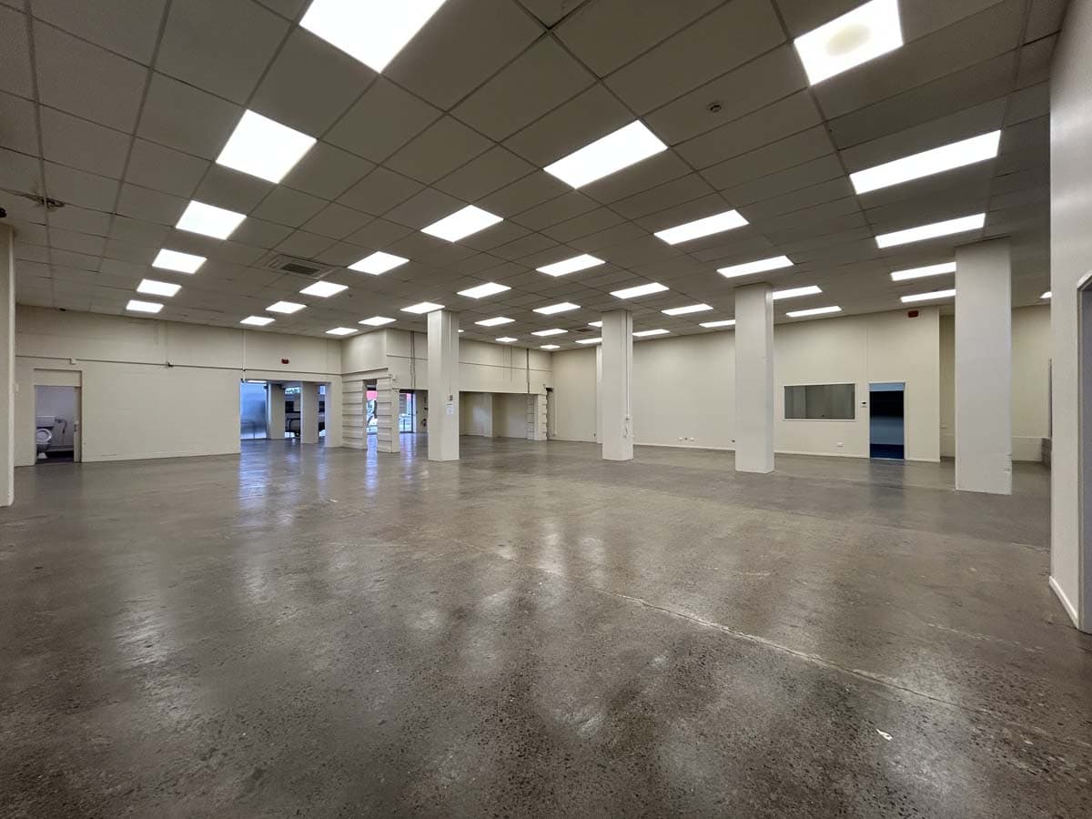 Empty commercial retail space in New Zealand with bright lighting and open layout.