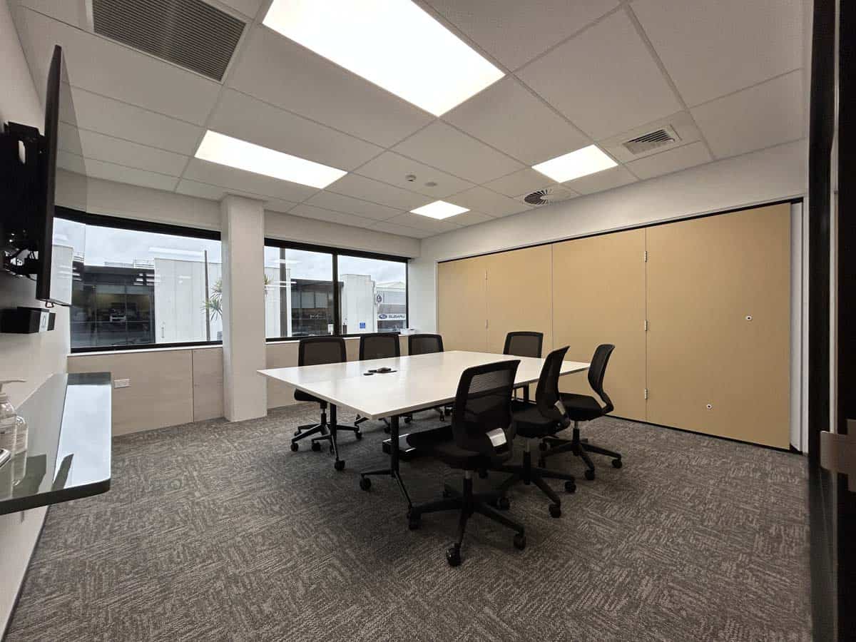 Bright office meeting space with conference table and ergonomic chairs.