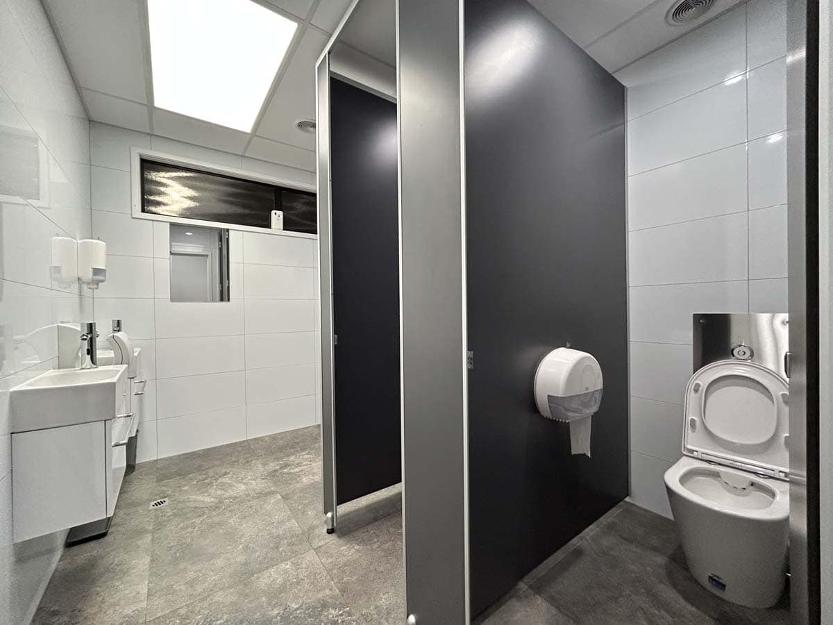 Public restroom with toilet and sink in a clean, modern facility.