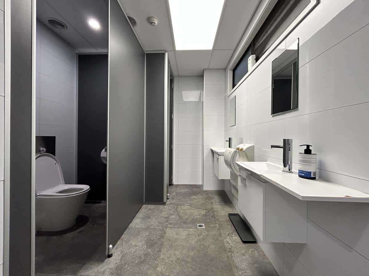 Modern bathroom with toilet, vanity, and sleek design in neutral tones.