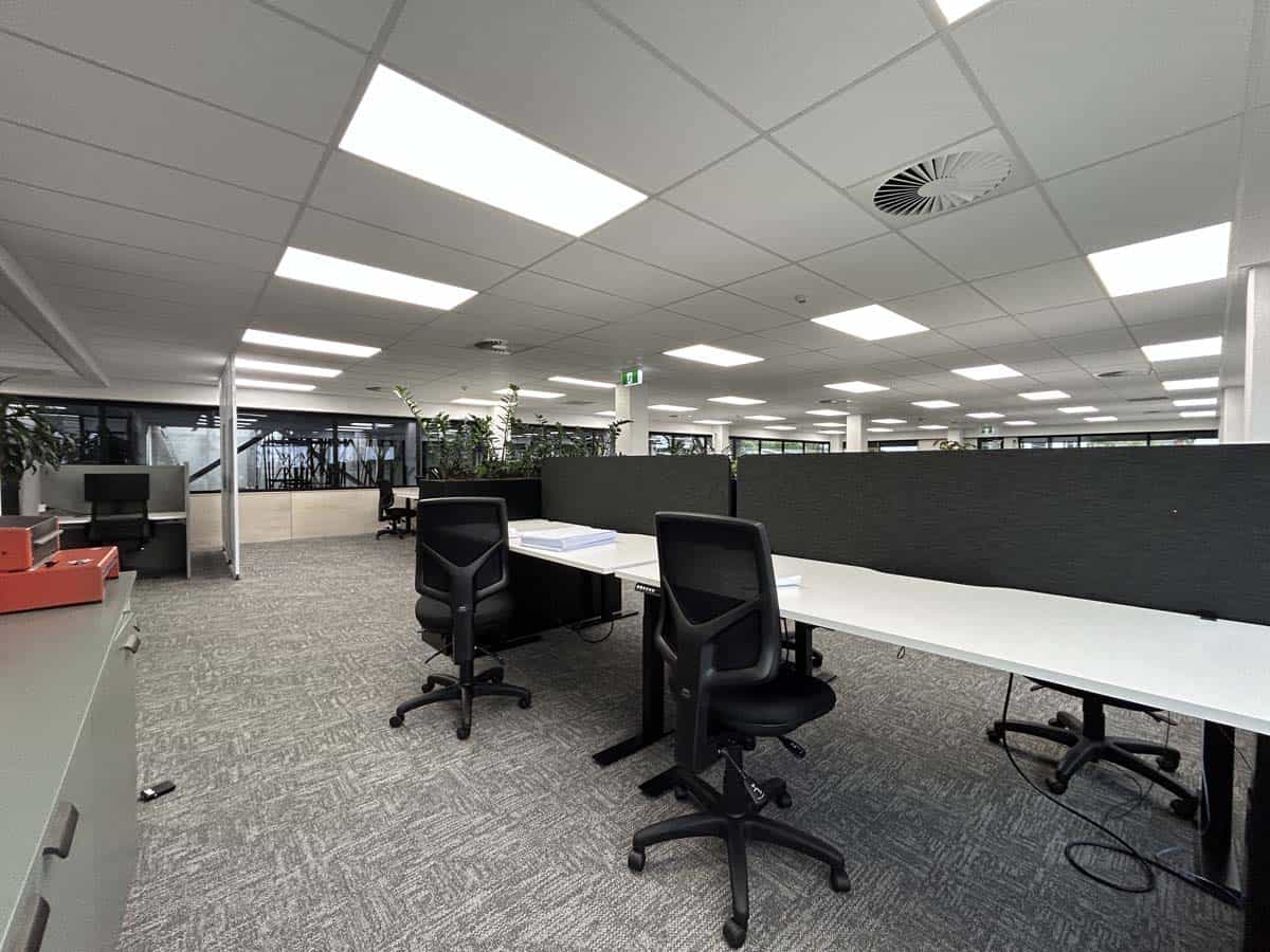 Modern office workspace with desks and chairs in a professional environment.