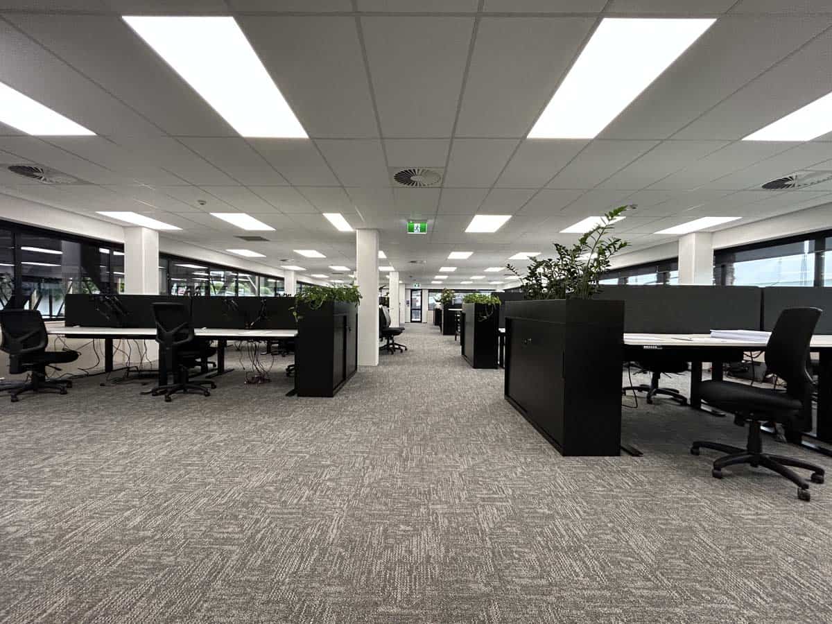 Modern open-plan office with desks and chairs in a corporate environment.